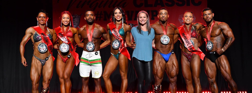 Corry with 7 athletes standing on stage